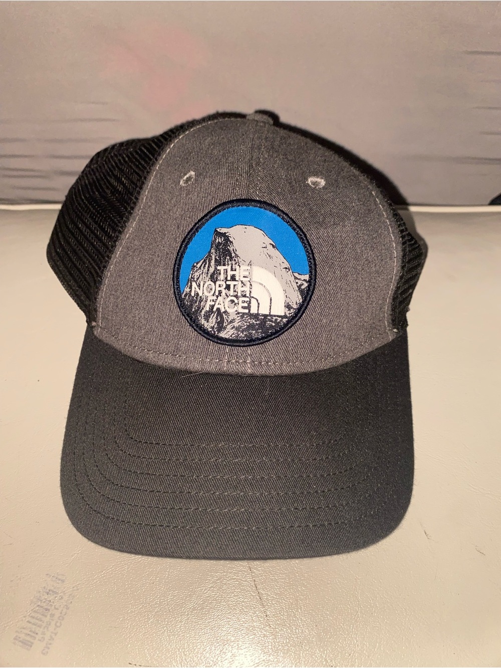 The North Face Men’s Two-Tone Patch Trucker Hat - Gray/Black with Blue Logo